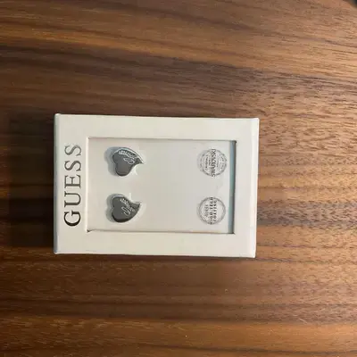 Joya Guess Pendientes plateados de corazón grabado